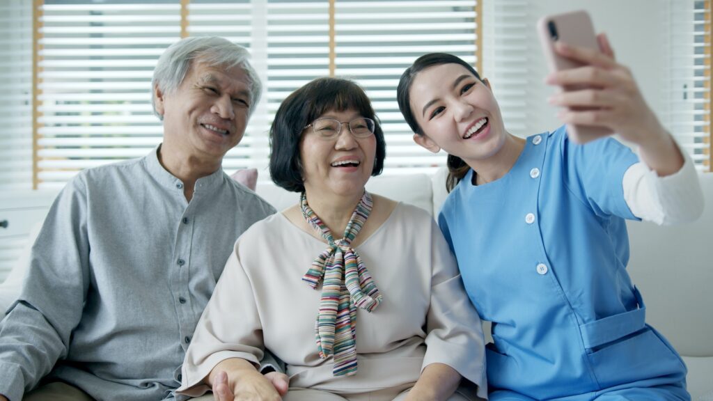 assisted home living nurse care hold mobile phone selfie videocall online at home